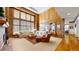 Spacious living room boasts wooden paneling, large windows, and a cozy seating area with sofas at 6414 E Stanford Ave, Cherry Hills Village, CO 80111