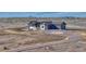 Eye-level aerial view of modern home featuring gray siding, dark trim, an unfinished landscape with a gravel driveway at 1740 Joseph Cir, Elizabeth, CO 80107