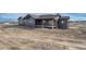 Eye-level aerial view of modern home featuring gray siding, dark trim, a small patio and an unfinished landscape at 1740 Joseph Cir, Elizabeth, CO 80107