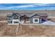A modern-style home with gray siding and stone accents. Large front yard with a newly poured driveway at 1740 Joseph Cir, Elizabeth, CO 80107