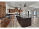 Modern kitchen with wood cabinets, island with dark countertop, stainless steel appliances, and open floor plan at 1740 Joseph Cir, Elizabeth, CO 80107