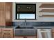 Up close, the kitchen sink and dishwasher are surrounded by custom wood cabinetry and shelving at 1740 Joseph Cir, Elizabeth, CO 80107
