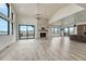 Spacious living room with stone fireplace, hardwood floors, modern light fixture and open-concept to the kitchen at 1740 Joseph Cir, Elizabeth, CO 80107