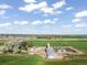 Expansive aerial view of a charming farm with red barns, green pastures, and a classic silo at 1805 W County Road 8, Berthoud, CO 80513