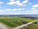Vast farmland seen from above, with barns, silos, and a highway bordering the property at 1805 W County Road 8, Berthoud, CO 80513