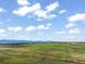 Expansive green farmland and pastures are visible, with a winding stream cutting through the landscape at 1805 W County Road 8, Berthoud, CO 80513