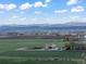 Scenic aerial view of farmland featuring a farm with multiple outbuildings and a backdrop of mountains at 1805 W County Road 8, Berthoud, CO 80513
