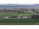 Picturesque aerial view of farmland with mountain views, barns, and open fields for agricultural use at 1805 W County Road 8, Berthoud, CO 80513