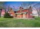 Charming two-story red home with a well-maintained lawn, a covered porch, and multiple windows at 1805 W County Road 8, Berthoud, CO 80513