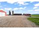 Farm scene with multiple red outbuildings and silos set against a blue sky, ideal for agricultural endeavors at 1805 W County Road 8, Berthoud, CO 80513