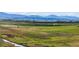 Beautiful landscape view of the open field with a small stream and mountains in the background at 1805 W County Road 8, Berthoud, CO 80513