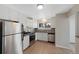 Modern kitchen with stainless steel appliances, white cabinetry, and tiled backsplash at 12501 Randolph Pl, Denver, CO 80239