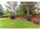 A lush backyard with mature trees, manicured lawn, and garden at 5473 W Prentice Ct, Littleton, CO 80123