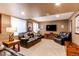 Comfortable basement living area with plush seating, large television, and neutral carpeting at 5473 W Prentice Ct, Littleton, CO 80123