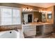 Bathroom featuring a soaking tub, double sink vanity, and tiled floor at 5473 W Prentice Ct, Littleton, CO 80123