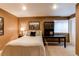 Cozy bedroom with a comfortable bed, a desk, and a window letting in natural light at 5473 W Prentice Ct, Littleton, CO 80123