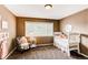Bedroom with a white crib, plush chair, and plenty of natural light from a large window at 5473 W Prentice Ct, Littleton, CO 80123