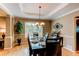Stylish dining room featuring a dark wood table set for dinner, a chandelier, and a window providing natural light at 5473 W Prentice Ct, Littleton, CO 80123