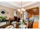 Dining room with dark wood table set for a meal, chandelier, and view of staircase at 5473 W Prentice Ct, Littleton, CO 80123