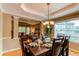Elegant dining room with a dark wood table set for a meal, a view into the living room, and a window at 5473 W Prentice Ct, Littleton, CO 80123