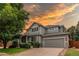 Charming two-story home with a well-manicured lawn, mature trees, and a welcoming two-car garage during sunset at 5473 W Prentice Ct, Littleton, CO 80123