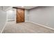 Finished basement featuring neutral carpet, gray walls, and a rustic wood barn door to another room at 2980 S Parker Ct, Aurora, CO 80014
