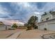 Townhome exterior with garage parking, landscaping, a treeline, and a modern office building in the distance at 2980 S Parker Ct, Aurora, CO 80014