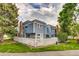 View of a blue townhome with a white picket fence and mature shade trees at 2980 S Parker Ct, Aurora, CO 80014