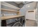 Laundry room featuring a butcher block countertop, modern washer/dryer, and open shelving for storage at 2980 S Parker Ct, Aurora, CO 80014