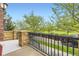 A balcony view featuring wrought iron railing overlooking mature trees and green space at 10311 Belvedere Ln, Lone Tree, CO 80124