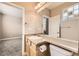 Bright bathroom with a large mirror, tan tiled walls, modern fixtures, and natural light from the window at 10311 Belvedere Ln, Lone Tree, CO 80124