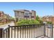 View of the charming townhome from the porch featuring a brick chimney and lush green landscaping at 10311 Belvedere Ln, Lone Tree, CO 80124