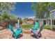 Charming backyard with a stone patio, colorful chairs around a fire pit, and mature trees at 8361 Mason Cir, Westminster, CO 80031