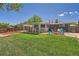 Expansive backyard features well-kept lawn, covered patio, brick accents, and a cozy fire pit at 8361 Mason Cir, Westminster, CO 80031