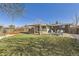 Spacious backyard featuring a covered patio, lush lawn, brick accents, and cozy firepit with Adirondack chairs at 8361 Mason Cir, Westminster, CO 80031