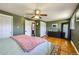 Spacious bedroom featuring hardwood floors, green walls, a ceiling fan, and large closet at 8361 Mason Cir, Westminster, CO 80031