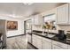 Modern kitchen with white cabinets, black countertops, stainless steel appliances, and a view out the window at 8361 Mason Cir, Westminster, CO 80031