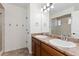 Bathroom with double sinks, wood cabinets, and a walk-in shower at 19060 E 54Th Pl, Denver, CO 80249