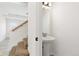 Half bathroom with a pedestal sink in a hall leading to the stairwell at 19060 E 54Th Pl, Denver, CO 80249