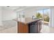 Bright kitchen with tile floors, an island, and stainless steel dishwasher overlooking the backyard at 19060 E 54Th Pl, Denver, CO 80249