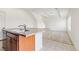 Bright kitchen with wood cabinets, an island, and tile floors leading to an open living space at 19060 E 54Th Pl, Denver, CO 80249