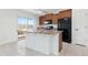 Bright kitchen with wood cabinets, an island, tile floors, and stainless steel appliances at 19060 E 54Th Pl, Denver, CO 80249