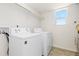 Bright laundry room with a large window and modern washer and dryer at 19060 E 54Th Pl, Denver, CO 80249