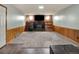 Finished basement featuring a cozy fireplace, wood paneling, and neutral carpeting at 7737 S Dover St, Littleton, CO 80128