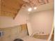 Unfinished basement features exposed beams and concrete walls, offering potential for customization at 7737 S Dover St, Littleton, CO 80128