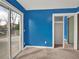 Bright bedroom featuring blue accent wall, sliding door access to deck, and closet at 7737 S Dover St, Littleton, CO 80128