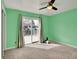 Bright bedroom with a sliding glass door to the deck, ceiling fan, and soft carpeting at 7737 S Dover St, Littleton, CO 80128