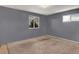 Bedroom features gray walls, carpet, and two windows offering natural light at 7737 S Dover St, Littleton, CO 80128