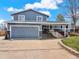 This home has a spacious two car garage, tidy lawn, and brick accents at 7737 S Dover St, Littleton, CO 80128