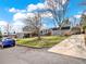 Suburban home with mature trees, lawn and long concrete driveway at 7737 S Dover St, Littleton, CO 80128